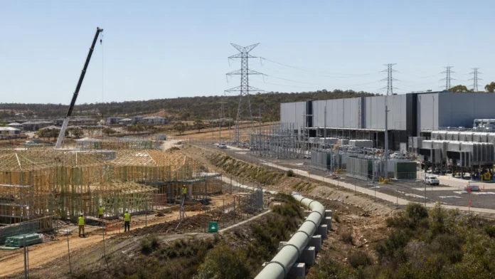 New housing construction beside a large Australian data centre competing for electricity and infrastructure.